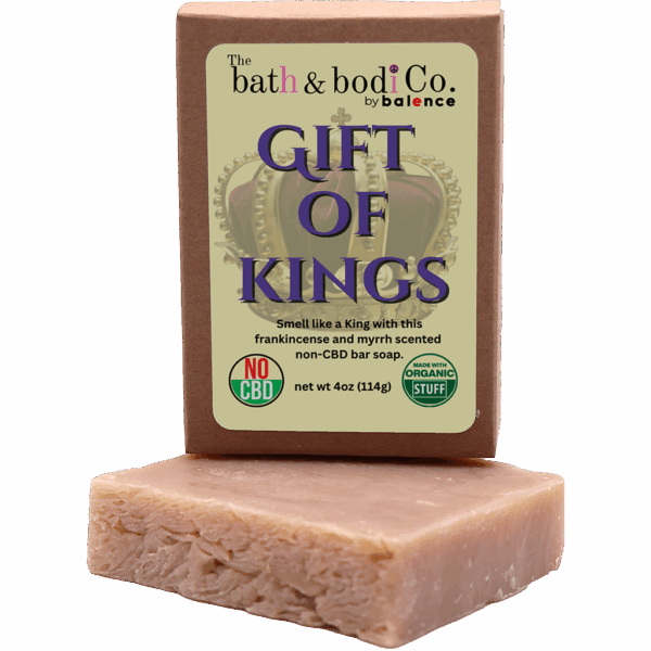 Balence Gift of Kings handmade soap on rustic wood with frankincense resin, myrrh chunks, cedar sprigs, sage leaves, and warm golden candlelight.