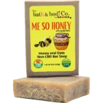 Balence Me So Honey handmade soap on rustic wood with a honey dipper, goat milk jar, rolled oats, and honeycomb in warm golden sunlight.