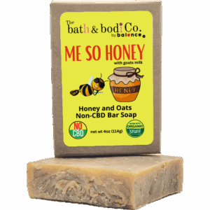Balence Me So Honey handmade soap on rustic wood with a honey dipper, goat milk jar, rolled oats, and honeycomb in warm golden sunlight.