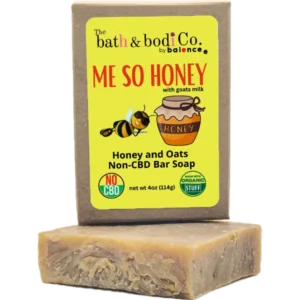 Balence Me So Honey handmade soap on rustic wood with a honey dipper, goat milk jar, rolled oats, and honeycomb in warm golden sunlight.
