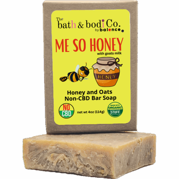 Balence Me So Honey handmade soap on rustic wood with a honey dipper, goat milk jar, rolled oats, and honeycomb in warm golden sunlight.