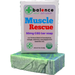 Balence Muscle Rescue hemp CBD soap on rustic wood with peppermint leaves, rosemary sprigs, eucalyptus stems, and orange slices in cool misty lighting.