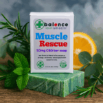 Balence Muscle Rescue hemp CBD soap on rustic wood with peppermint leaves, rosemary sprigs, eucalyptus stems, and orange slices in cool misty lighting.