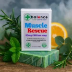 Balence Muscle Rescue hemp CBD soap on rustic wood with peppermint leaves, rosemary sprigs, eucalyptus stems, and orange slices in cool misty lighting.