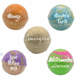 Five colorful Balence non-CBD bath bombs — Mango (orange), Monkey Farts (blue-yellow), Lemongrass (beige), Love Potion #9 (purple-gold), and Watermelon Lemonade (pink-green) — arranged on a white background.