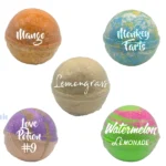 Five colorful Balence non-CBD bath bombs — Mango (orange), Monkey Farts (blue-yellow), Lemongrass (beige), Love Potion #9 (purple-gold), and Watermelon Lemonade (pink-green) — arranged on a white background.