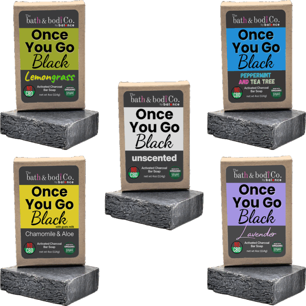 Balence Once You Go Black activated charcoal soap collection — solid black handmade bars with labels for Unscented, Lavender, Lemongrass, Peppermint & Tea Tree, and Chamomile & Aloe — displayed with herbs, flowers, and charcoal chunks on rustic wood.