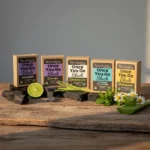 Balence Once You Go Black Activated Charcoal Soap Collection — five solid black handmade bars with labels for Unscented, Lavender, Lemongrass, Peppermint & Tea Tree, and Chamomile & Aloe, each styled with its matching natural ingredients on rustic wood in soft golden light.