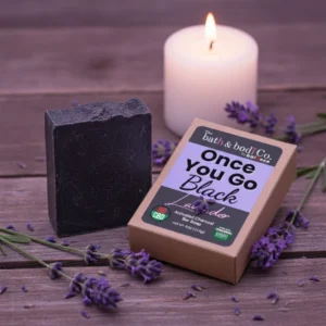Balence Once You Go Black Lavender solid black soap bar with label, surrounded by fresh lavender sprigs and buds on rustic wood with soft purple lighting.