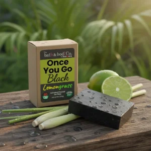 Balence Once You Go Black Lemongrass solid black soap bar with label, styled with lemongrass stalks and a halved lime on rustic wood in bright sunlight.
