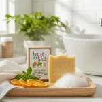 Balence Orange Spearmint Goat’s Milk Bar Soap on a wooden tray with orange slices, mint leaves, and creamy bubbles under morning sunlight — natural handcrafted skincare.