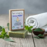 Balence Stress Relief handmade soap on rustic wood with eucalyptus sprigs, spearmint leaves, spirulina powder, and a spa towel in cool misty lighting.