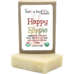 Balence Happy Hippie handmade soap bar on rustic wood with tie-dye cloth, hemp leaves, geranium flowers, patchouli sprigs, and incense smoke in warm sunlight.