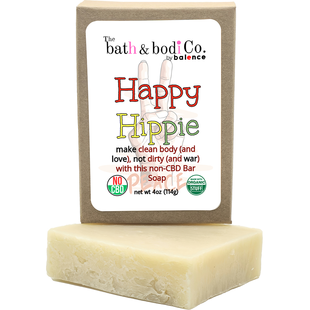 Balence Happy Hippie handmade soap bar on rustic wood with tie-dye cloth, hemp leaves, geranium flowers, patchouli sprigs, and incense smoke in warm sunlight.